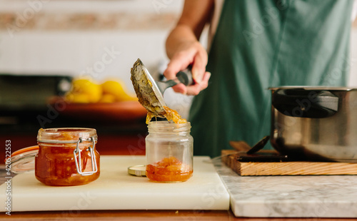 pouring finished marmalade into a jar photo