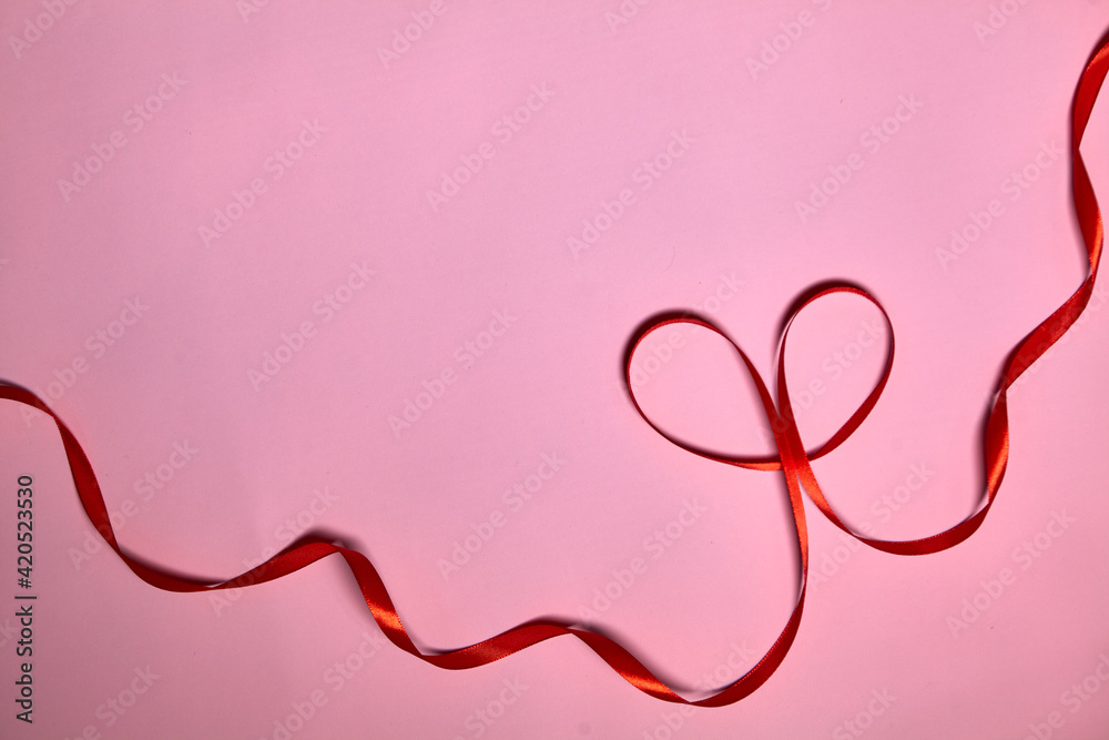Heart made of red ribbon on pink background, top view. Festive decoration. Heart shaped Ribbon. Valentines day greeting card Heart made of red ribbon on pink background, top view. Festive decoration. Heart shaped Ribbon. Valentines day greeting card