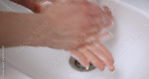 Close-up woman washes her hands with soap to protect health.