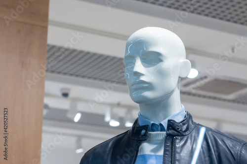 A mannequin behind a shop window in a trade center.