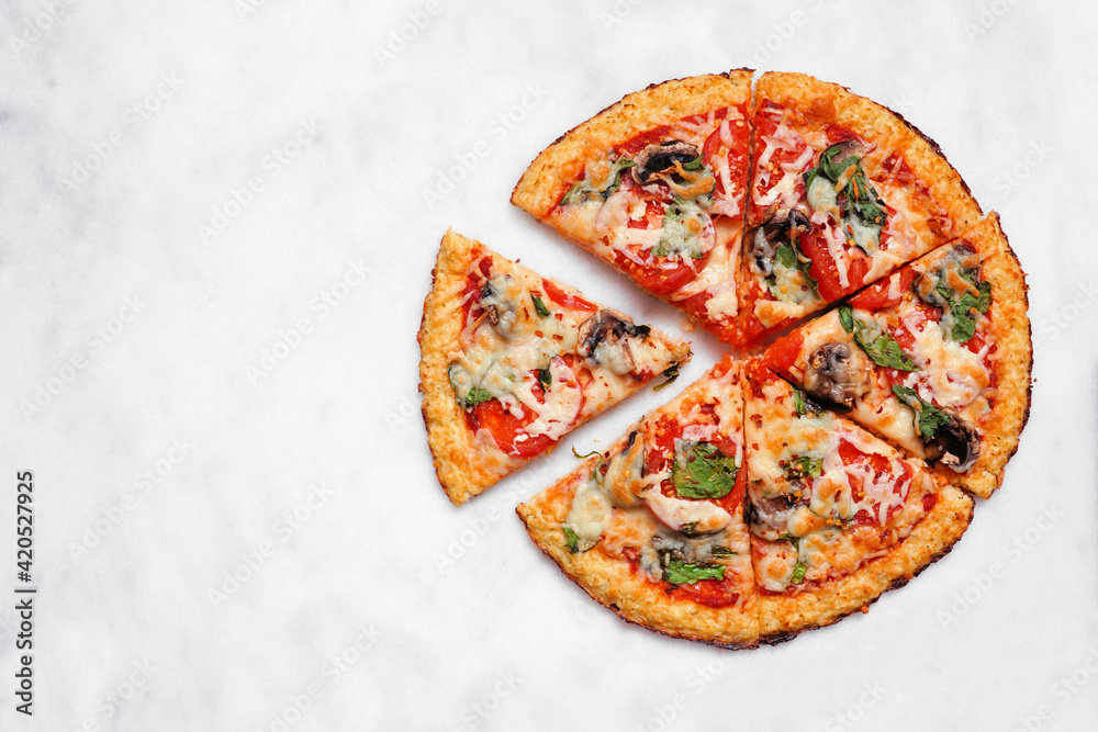 © Jenifoto - Healthy, gluten free cauliflower crust pizza with tomatoes, mushrooms and spinach. Overhead view with cut slices on a white marble background. © Jenifoto - Healthy, gluten free cauliflower crust pizza with tomatoes, mushrooms and spinach. Overhead view with cut slices on a white marble background.