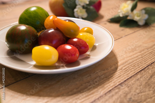 木目のテーブルに置かれた様々な種類のトマト