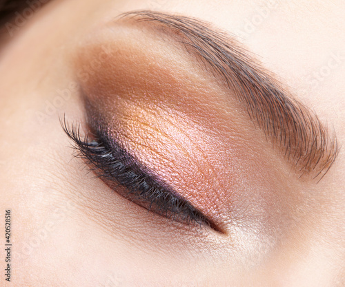 Closeup macro shot of closed human female eye. Girl with perfect skin and  pink eyes shadows