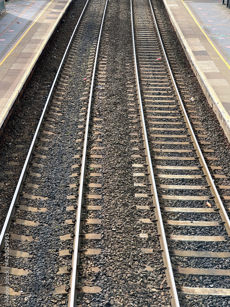 Aerial view of railway track and concrete railway sleepers, between platforms at a railway station.. No people. Aerial view of railway track and concrete railway sleepers, between platforms at a railway station.. No people.