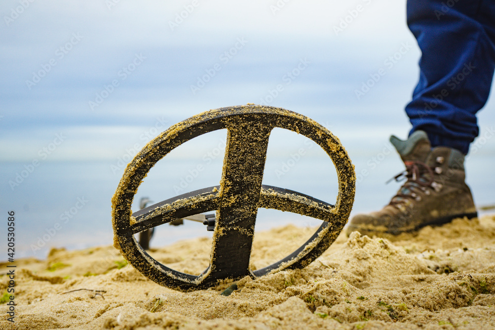 Fototapeta premium Man with metal detector on sea beach