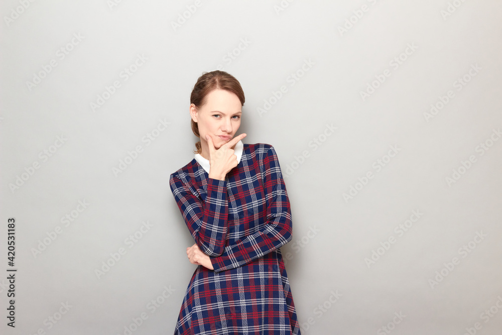 Portrait of thoughtful young woman touching chin and thinking hard Portrait of thoughtful young woman touching chin and thinking hard