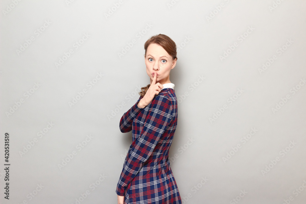 Portrait of strict woman showing silence gesture with finger over lips Portrait of strict woman showing silence gesture with finger over lips