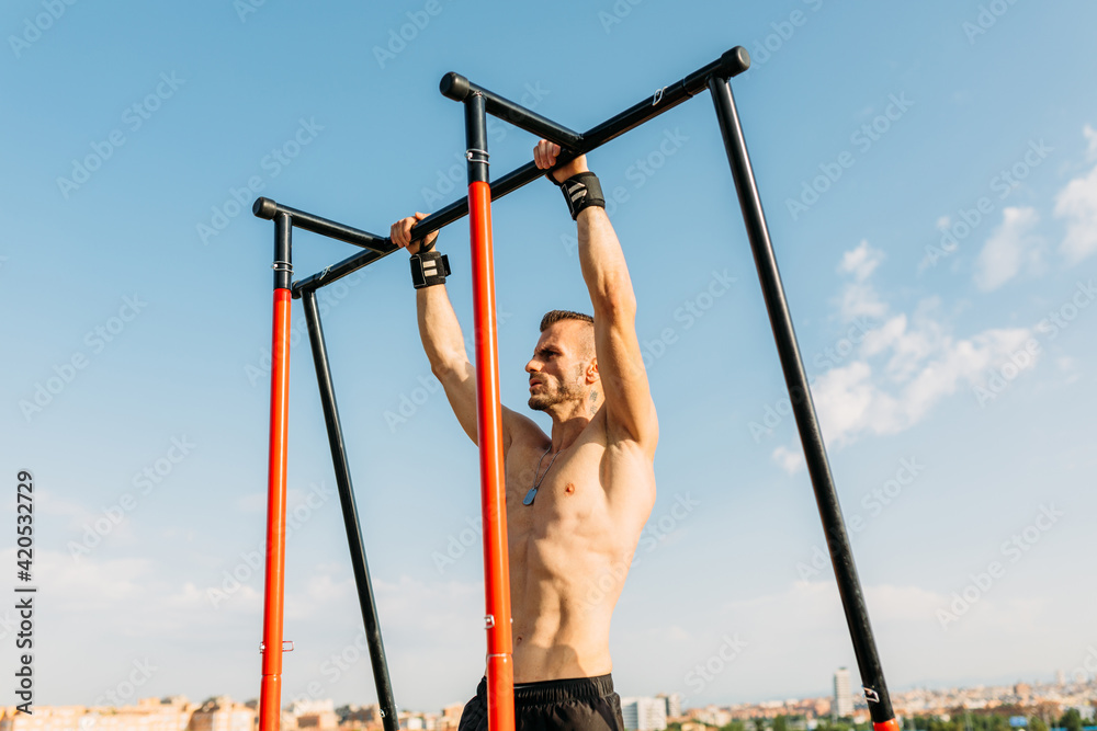 Muscular sportsman doing pull ups Muscular sportsman doing pull ups