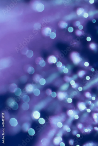 Blurred vertical sparkling blue and violet background. White round twinkles