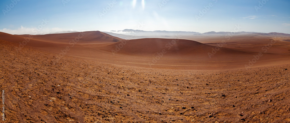 Naklejka premium Panoramic stock photography, from the top of the dunes, of the extreme desert landscape of Paracas, near Las Minas Beach, in the Paracas National Reserve, on a sunny and scorching day.