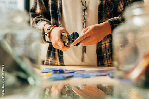 Photos Artist holding tweezers and making mosaic art while spending time at workplace