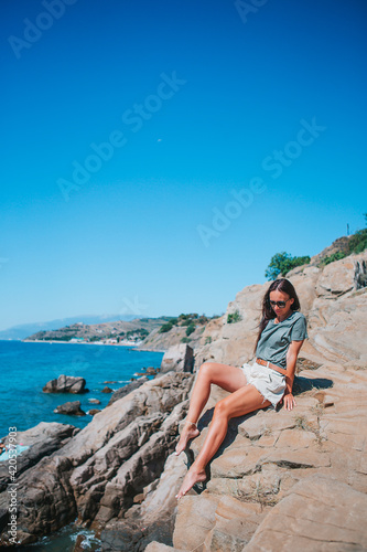 Tourist woman outdoor on edge of cliff seashore © travnikovstudio