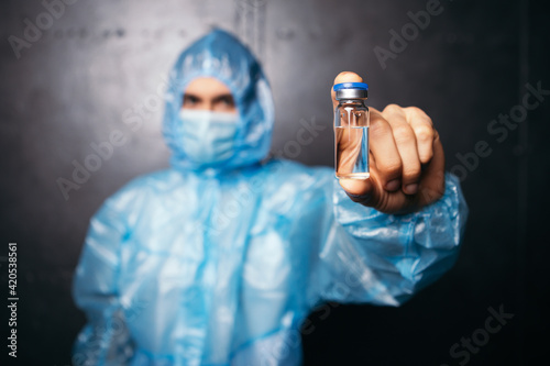 Nurse doctor hold vaccine injection prepare syringe. Liquid solution medication, drug. Vaccination concept. Man wear protective suit, face mask sterilized blue gloves. Coronavirus healthcare