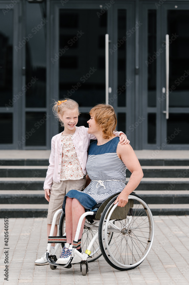 Mother with disability and daughter embracing on street Mother with disability and daughter embracing on street