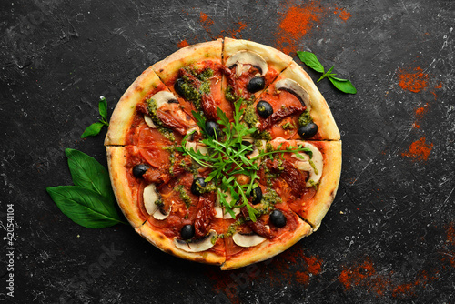 Homemade pizza with sun-dried tomatoes, mushrooms and olives. Italian cuisine. Food delivery.