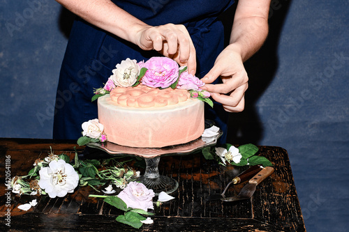 Women decorate the cake with fresh flowers