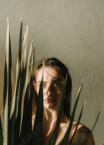 Portrait of a beautiful girl with palm leaf