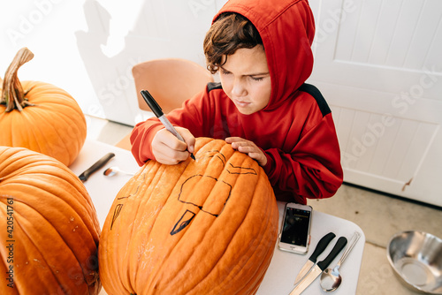 Boy designing pumpkin. photo