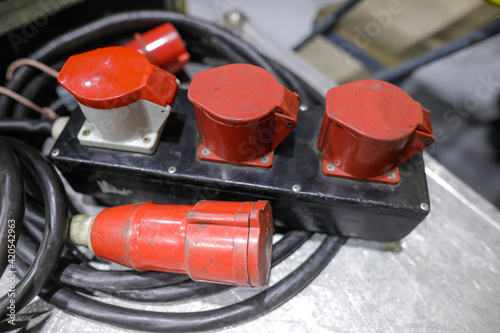 Shallow depth of field (selective focus) image with industrial and multiphase electrical plugs and sockets. photo