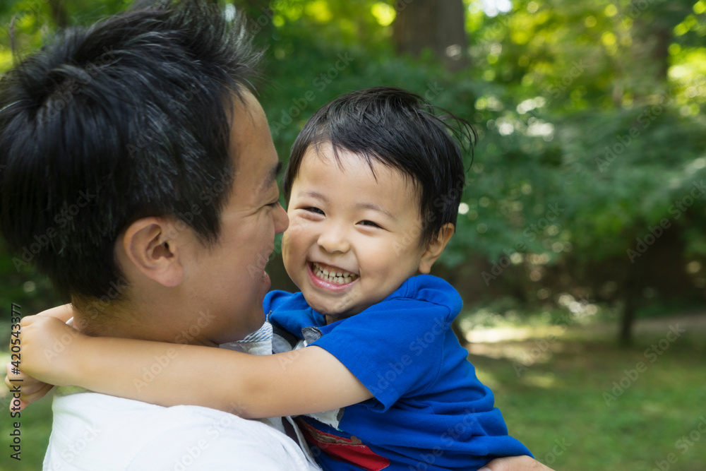 Asian father hugging a little boy outside Asian father hugging a little boy outside
