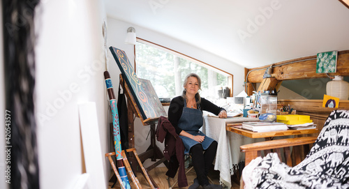 Mature woman portrait with art in her home loft studio.