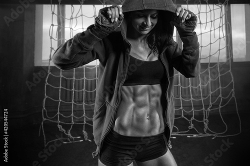 Portrait of a smiling beautiful woman in a sweatshirt at the gym. Fitness, bodybuilding, sports concept.