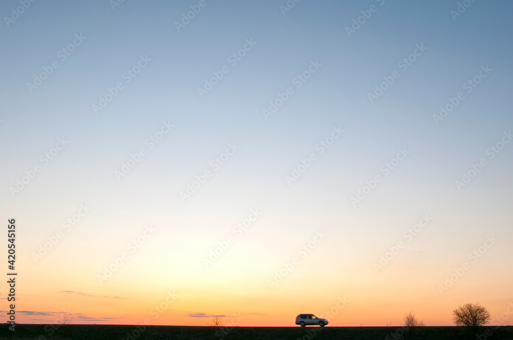 Panorama of dawn fire in the sky above the natural pasture. Golden red clouds just before sunrise. Picturesque landscape at sunrise. Beauty in nature