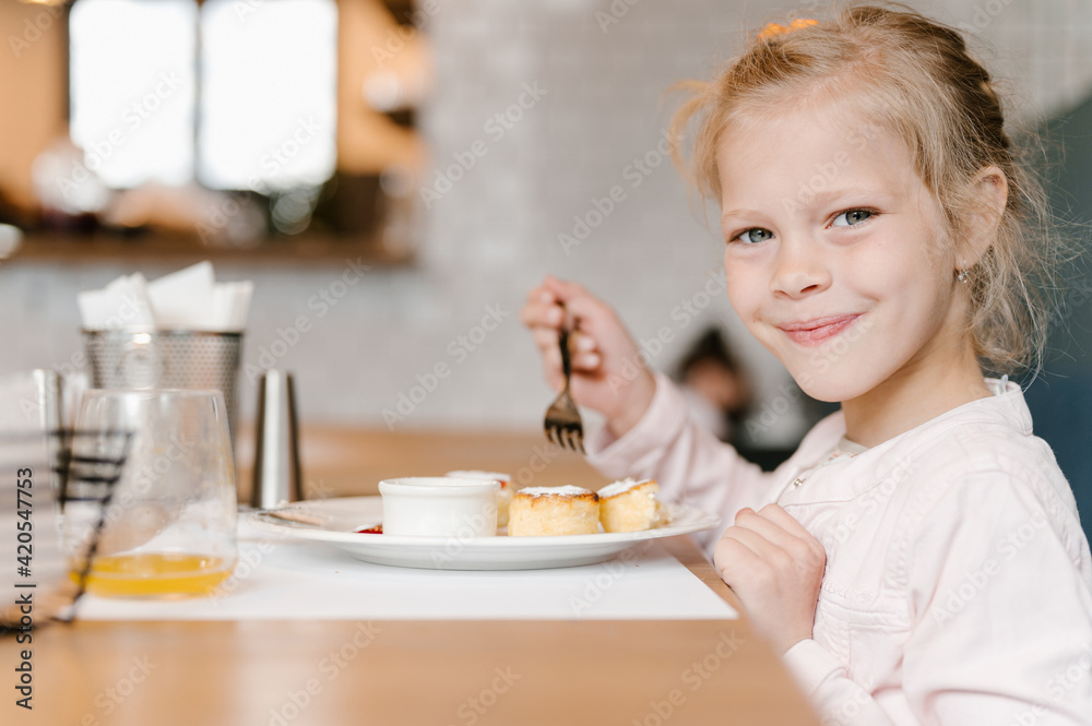 Cute girl eating cheesecake in cafe