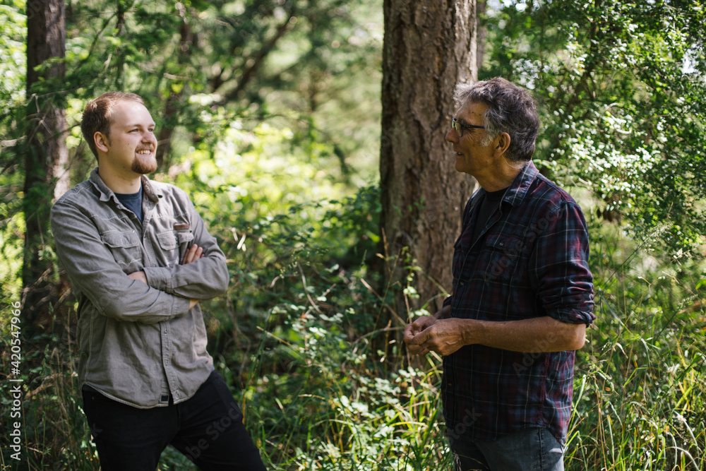 Mature father and grown son talking outside in nature Mature father and grown son talking outside in nature