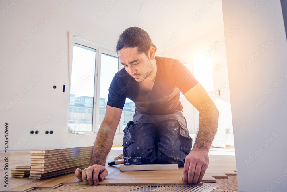 Handwerker verlegt parkettboden in einem Haus. Handwerker verlegt parkettboden in einem Haus.