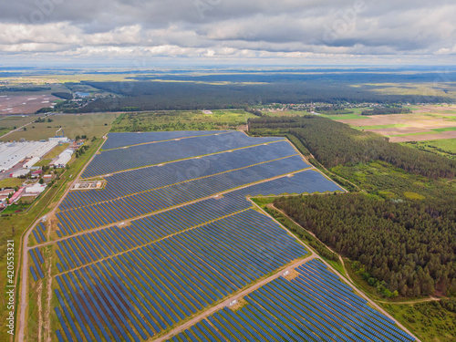 Solar panel produces green, environmentaly friendly energy from the setting sun. Aerial view from drone. photo