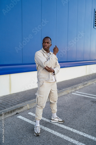 Chico negro apuesto posando delante de una pared azul y puerta blanca © MiguelAngelJunquera