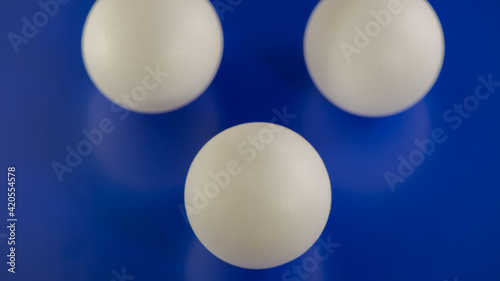 Three white balls on a blue background.