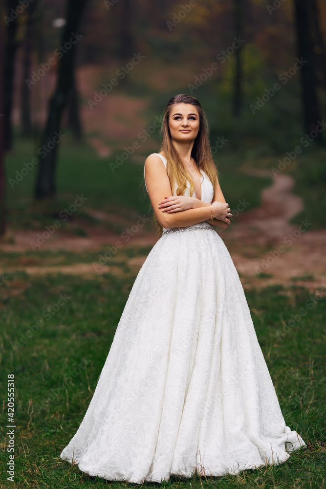 the bride in a beautiful wedding dress crossed her arms and look