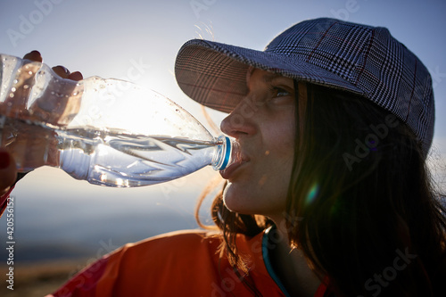 Woman consuming drink in mountains.