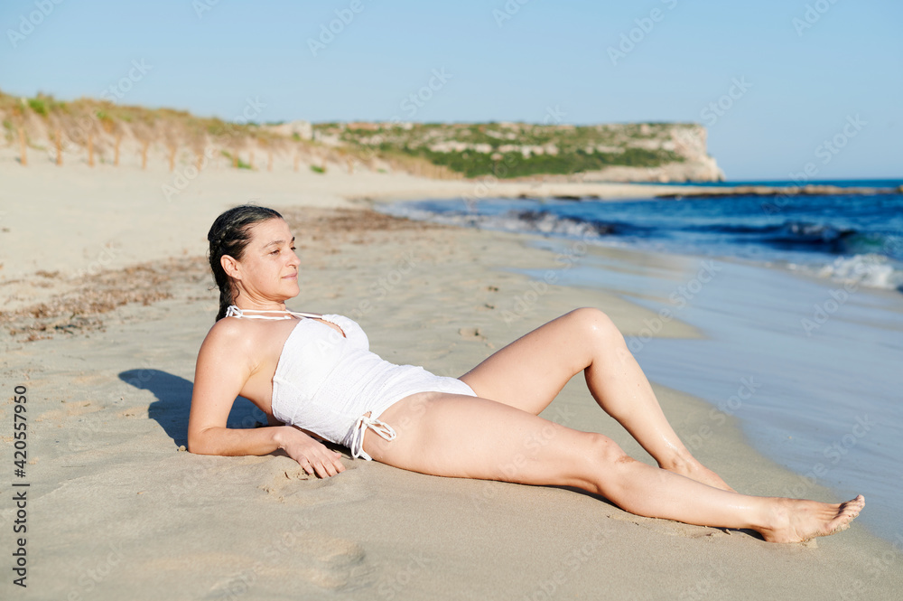 Woman sun tanning on a sandy beach Woman sun tanning on a sandy beach