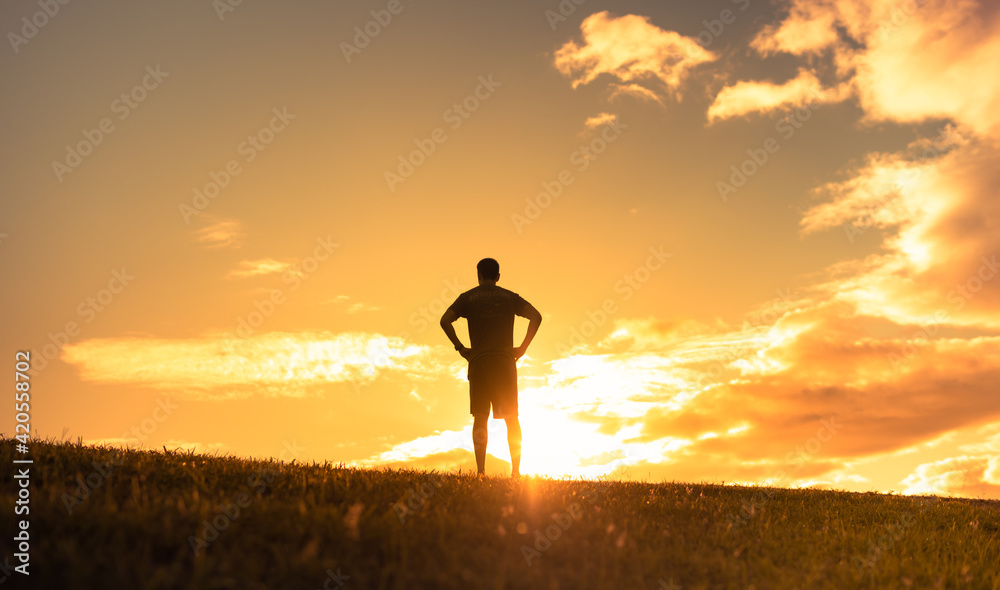 People enjoying nature. Young man in a relaxed state of mind watching a beautiful sunrise. 