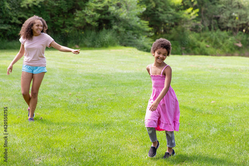 Sisters running and chasing each other in a game of tag