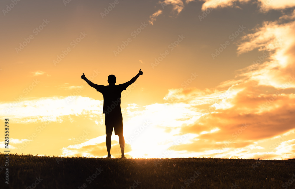 Happy young man feeling free putting arms up to the sunset sky feeling good. Happy young man feeling free putting arms up to the sunset sky feeling good.