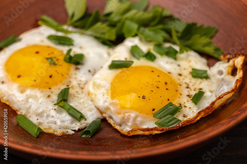 fried eggs with green onions close up	