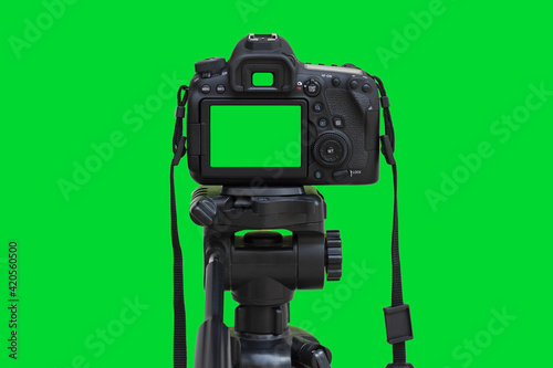Foto Dslr camera with green screen on the tripod isolated on green background