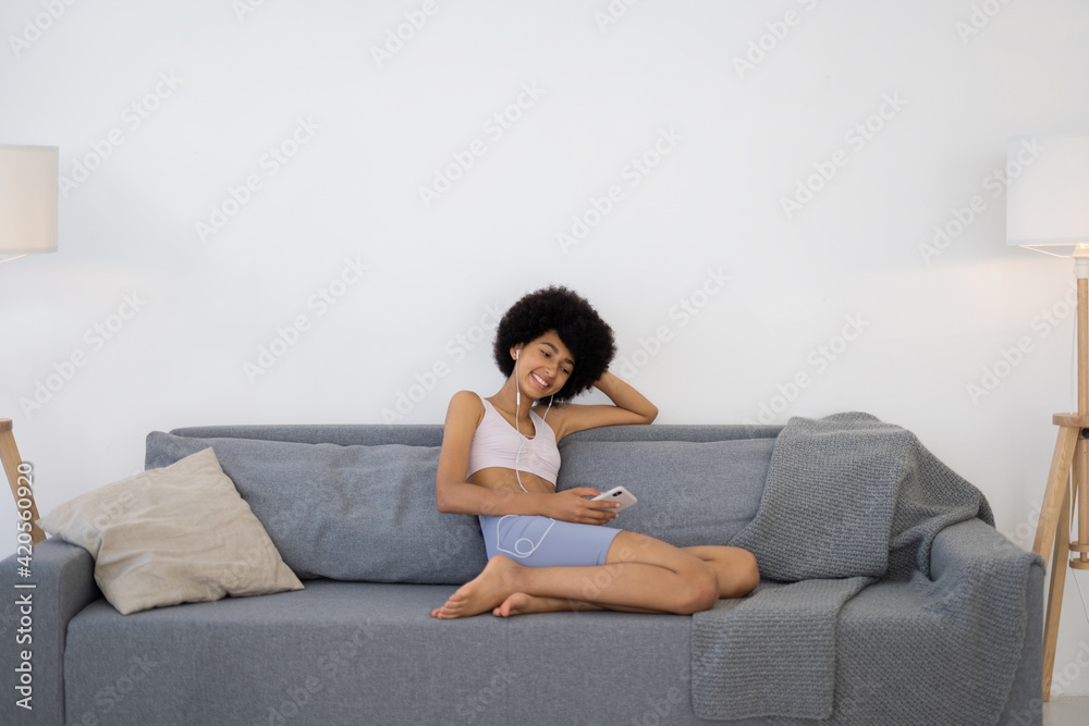 Woman Uses the Phone While Relaxing After Doing Yoga Woman Uses the Phone While Relaxing After Doing Yoga