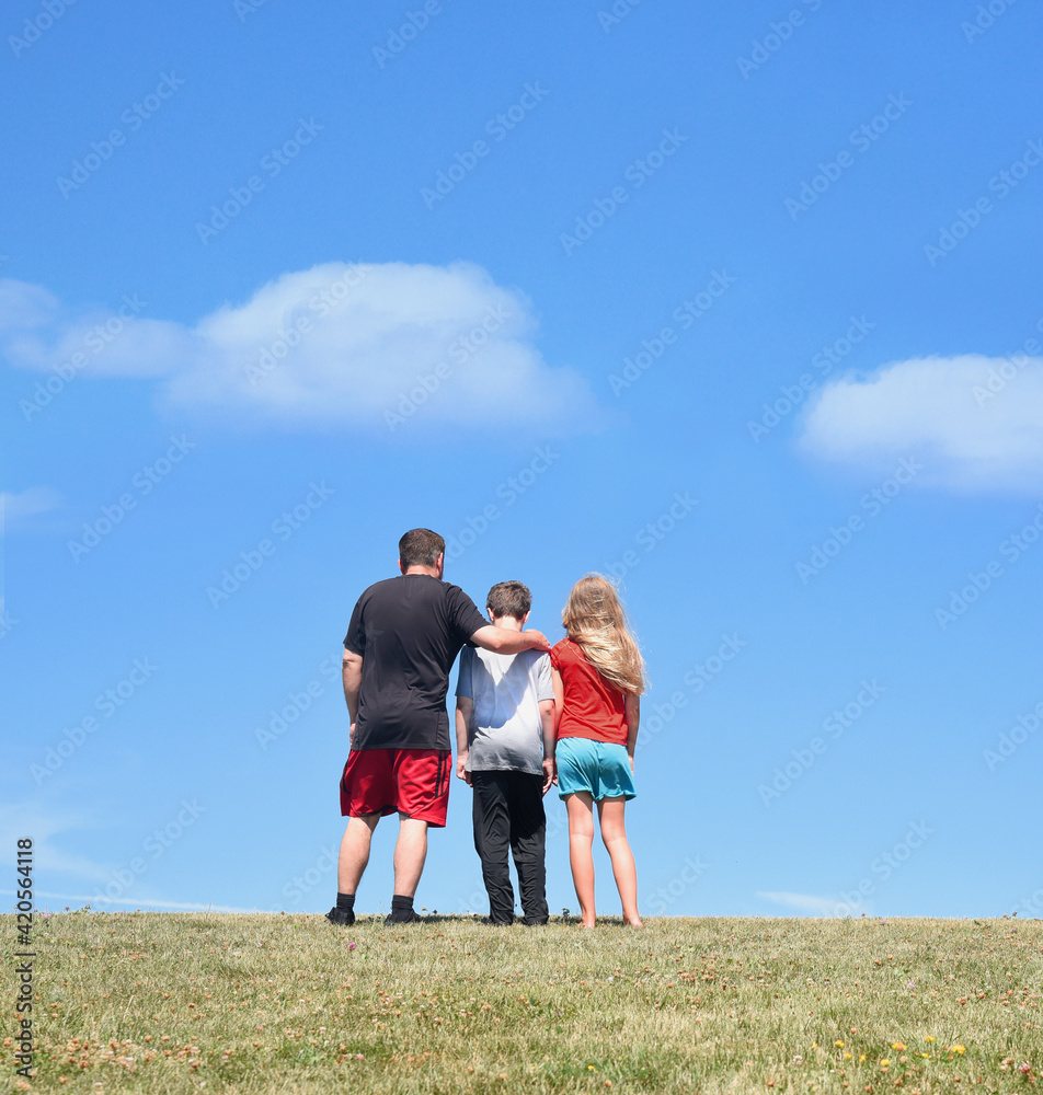 Father and Children Standing on Hill Together Outside Father and Children Standing on Hill Together Outside