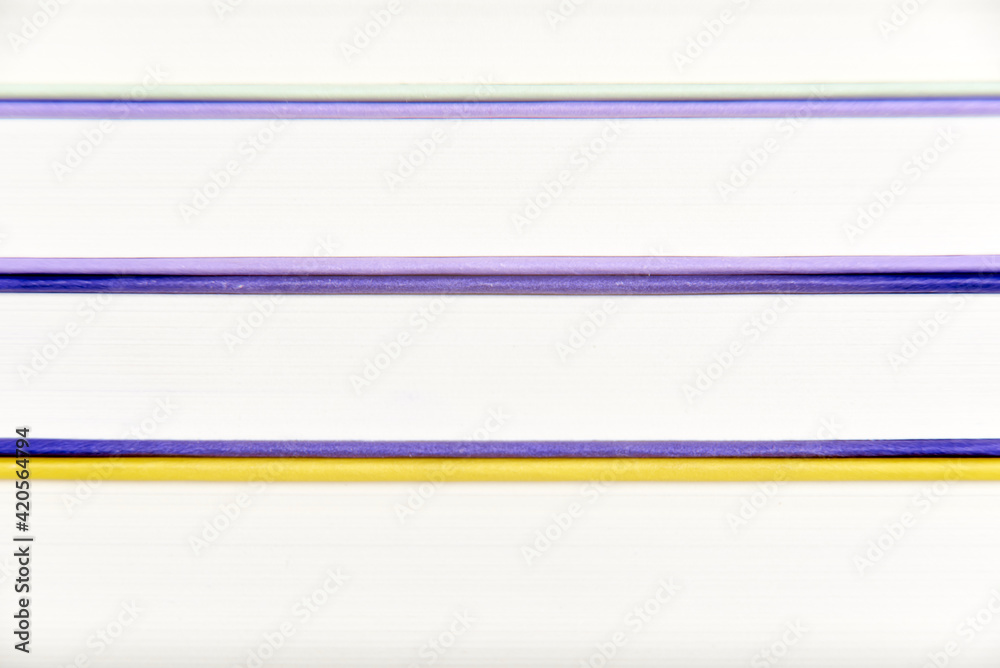Background, front view of a stack of books. Colored lines and white stripes