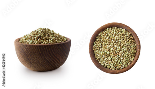 Wooden bowl with green buckwheat isolated on white background. Close-up. Green buckwheat groats Isolated on white. Green buckwheat in different angles. Image with copy space for text. Superfood.