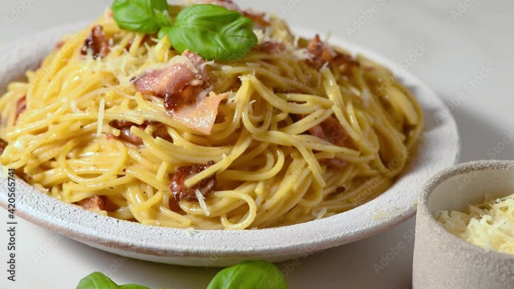 Pasta carbonara with bacon, cheese, basil and cream sauce with on white table. Full HD video. Italian food Pasta carbonara with bacon, cheese, basil and cream sauce with on white table. Full HD video. Italian food