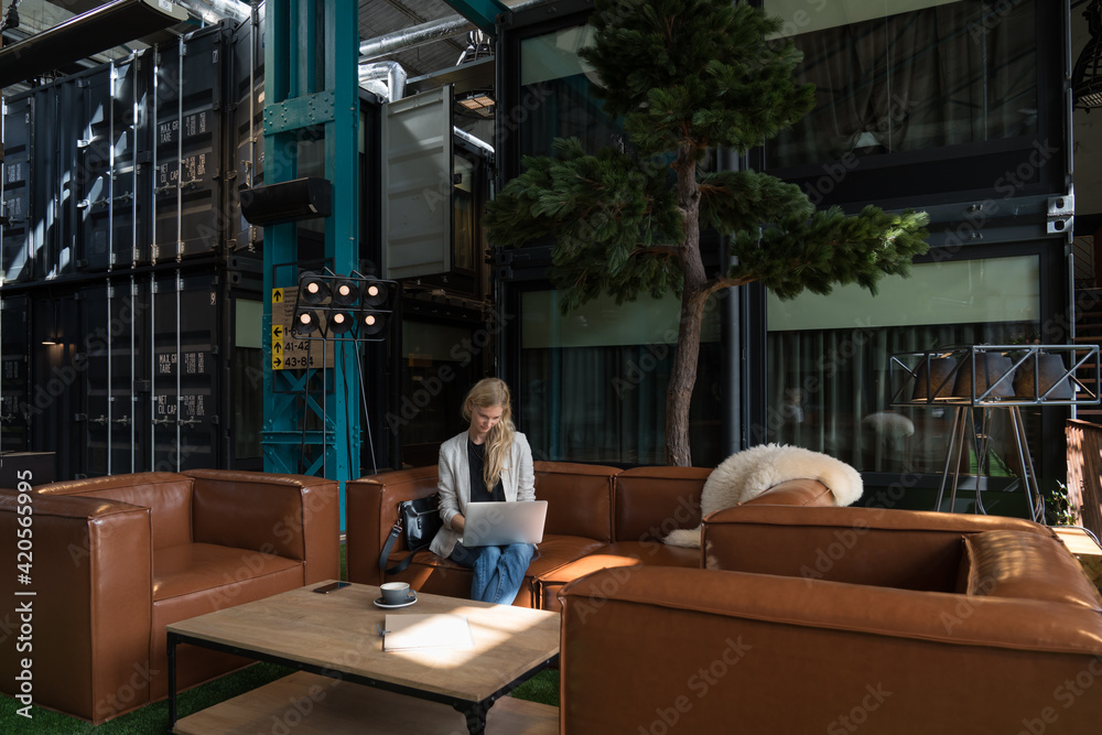 © Hernandez & Sorokina/Stocksy - Businesswoman Using Laptop In Lobby