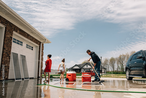 Family doing spring cleaning in driveway.