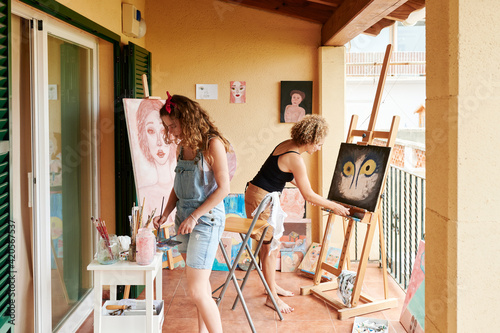 Mom and daughter painting on canvases at home