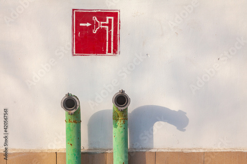 Fire fighting equipment on the wall of the house. Copyspace hydrant. Fire hydrant sign.
